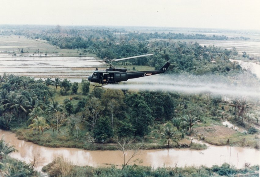 ベトナム戦争中、米軍ヘリが上空から枯葉剤を散布するようす(1960年代)。森や畑にまかれた除草剤が、戦争が終わってからも長く影を落とした。(Photo: U.S. Army / パブリックドメイン)