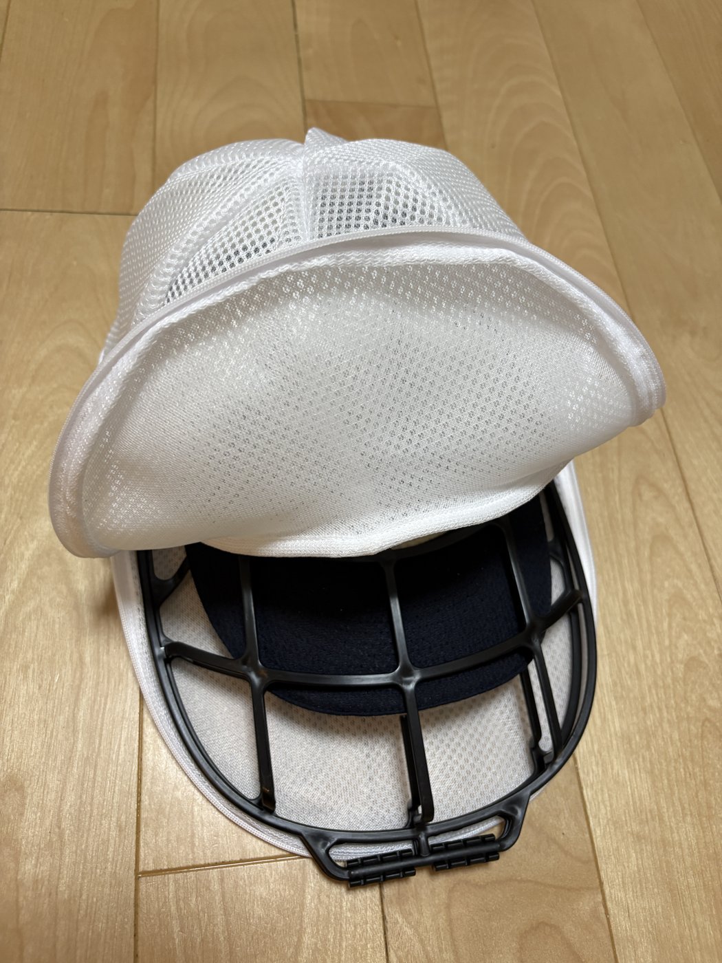 下のカゴに野球帽をセットし、上のカゴをかぶせているところ