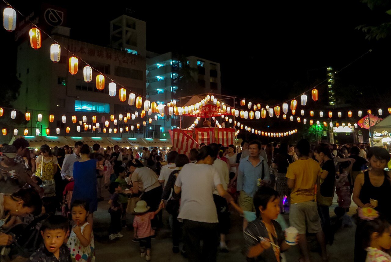 軒を連ねる提灯、櫓を囲む人の輪。子どものころ、夏の夜はいつもこんな景色の中にあった。（Photo: CC BY 2.0, via Wikimedia Commons ※イメージ）