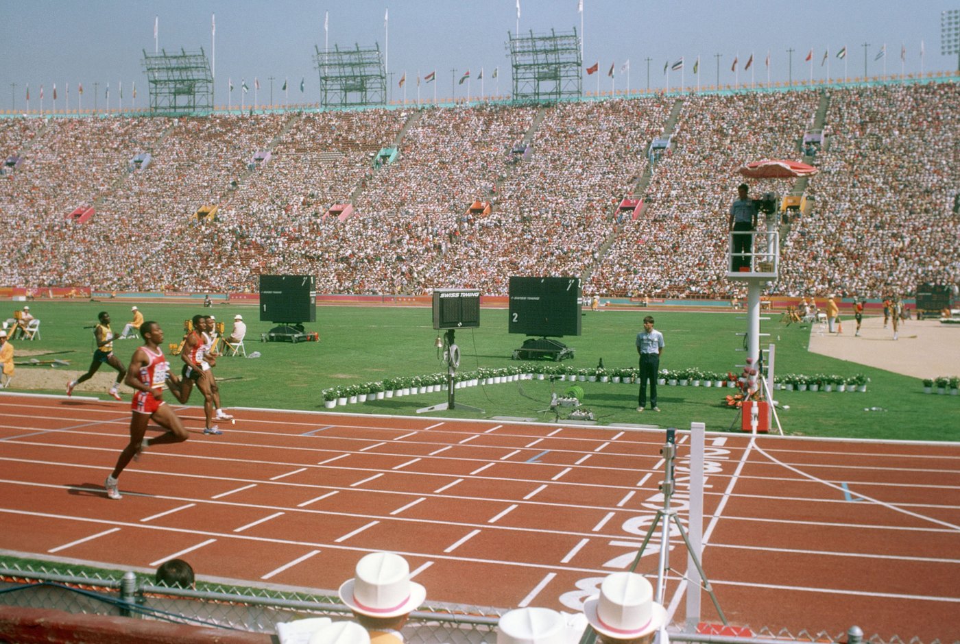 沸き返る1984年ロサンゼルス五輪のメイン会場、ロサンゼルス・メモリアル・コロシアム。満員のスタンドと、トラックを駆ける選手たち。(Photo: Ken Hackman, U.S. Air Force / パブリックドメイン)