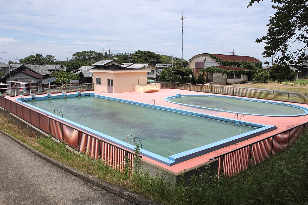 校庭の端に据えられた、屋外のプール。低学年用の小さいほうが隣にある。(Photo: CC BY-SA 4.0, via Wikimedia Commons)