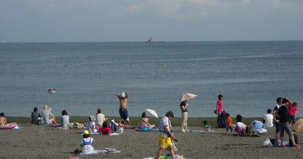 茅ヶ崎の「サザンビーチ」と、沖に浮かぶ烏帽子岩。夏が来るたび、どこかで桑田さんの声が流れている。（Photo: Goki / CC BY-SA 3.0, via Wikimedia Commons）