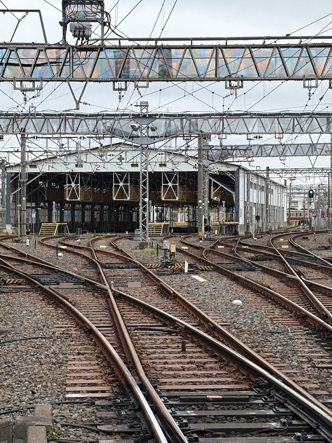 高砂検車区。会社の違う電車が、同じ屋根の下で肩を並べることもある。あの日つながった「輪」が、いまも回り続けている。