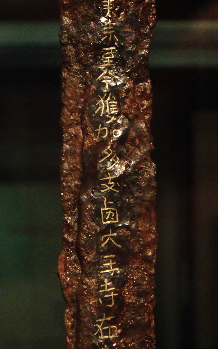 裏面の「獲加多支鹵大王」の部分。錆の中に、金の線で「ワカタケル大王」の文字が並ぶ。（Photo: 斑猫, CC0, via Wikimedia Commons）