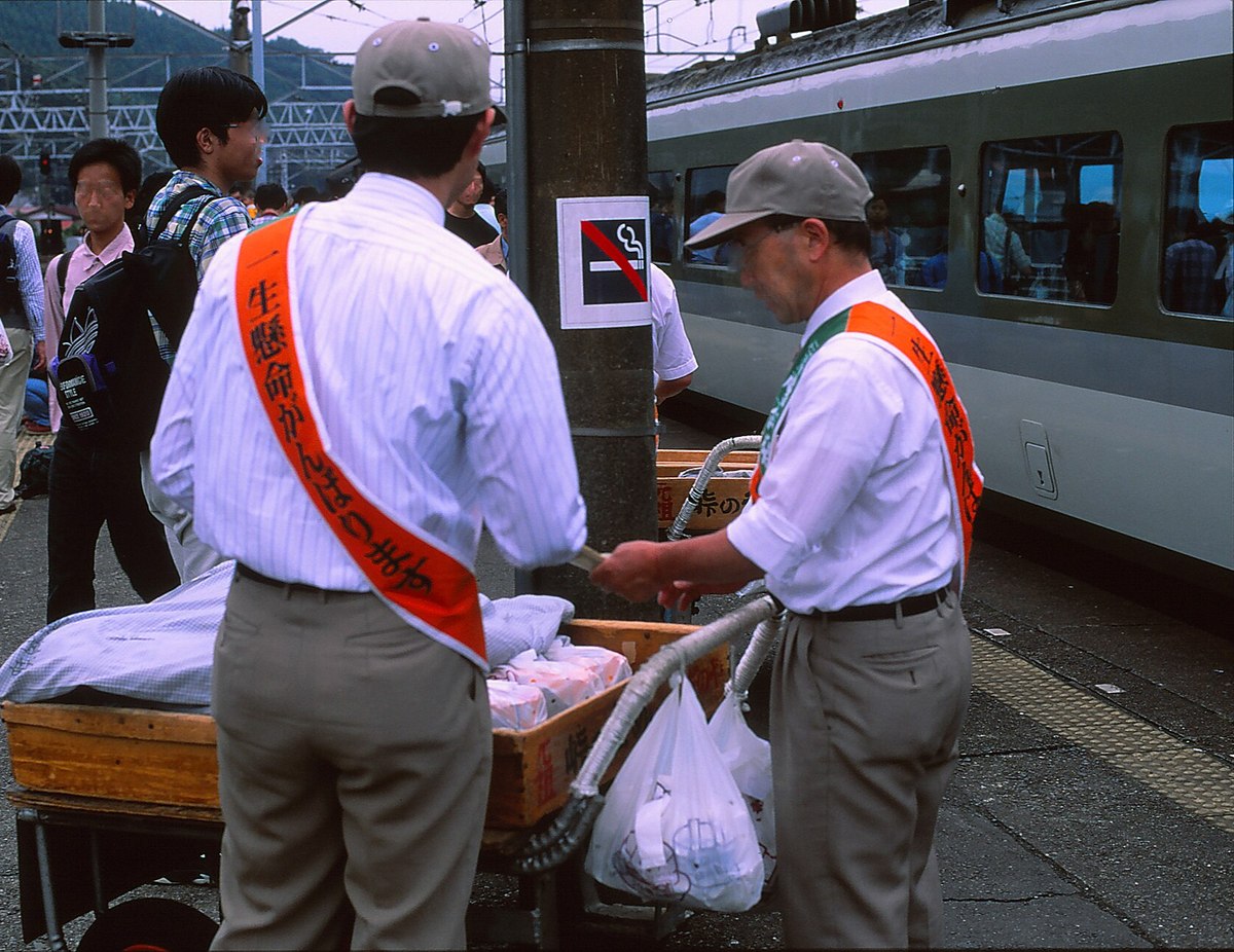 横川駅のホームで釜めしを売るおぎのやの人たち（平成9年9月）。峠越えの線路が廃止される、ひと月ほど前の風景。（Photo: Gohachiyasu1214, CC BY-SA 4.0, via Wikimedia Commons）